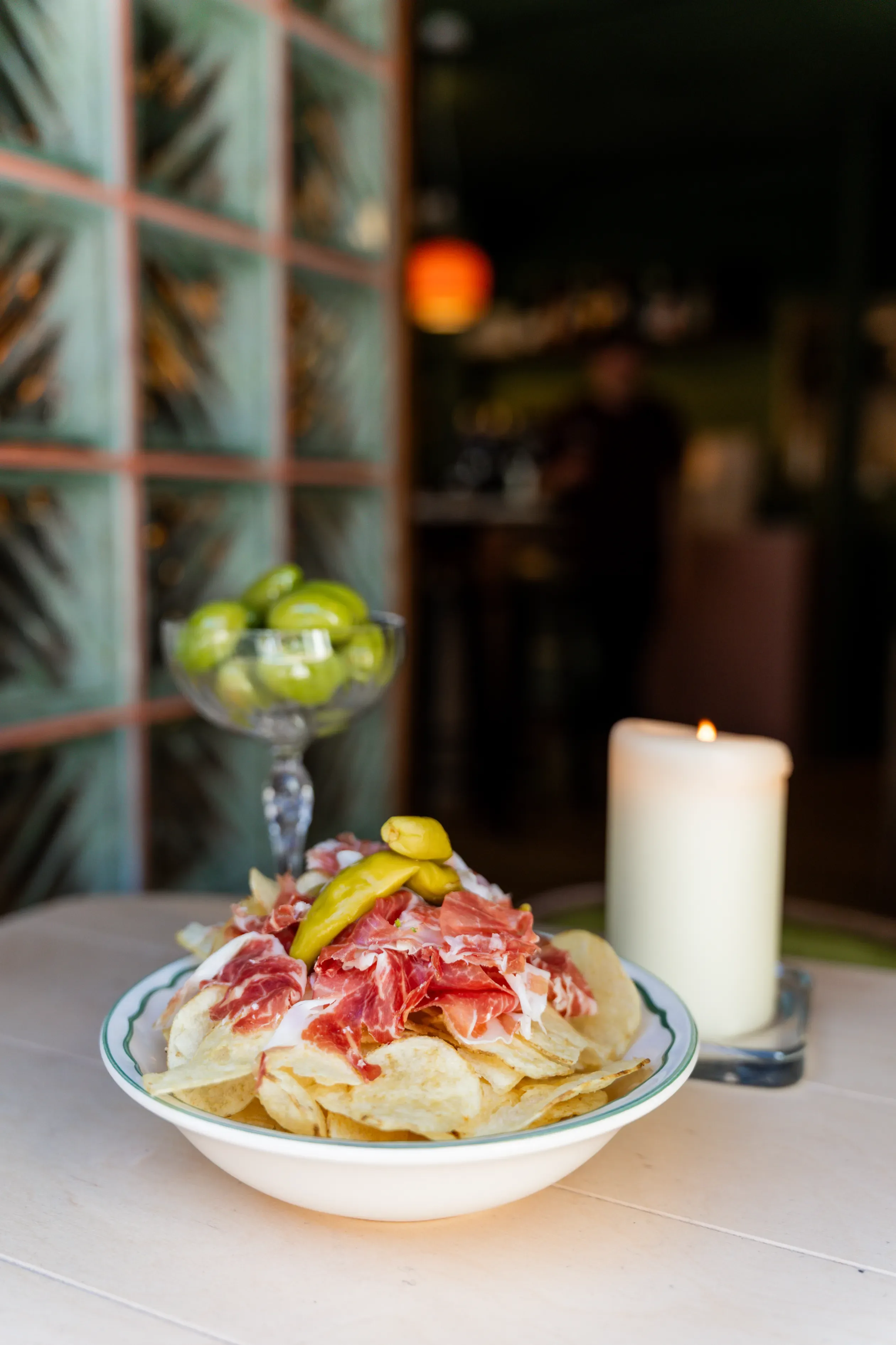 Pata negra op naturelchips met olijven en een kaars